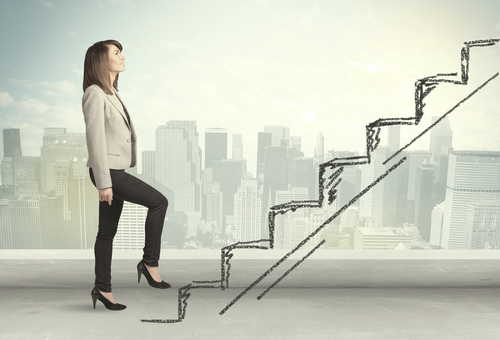 Businesswoman climbing a staircase on a city background